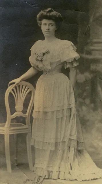 Portrait ancien de Louise de Bettignies, photographie en robe à volants debout près d'une chaise, archive