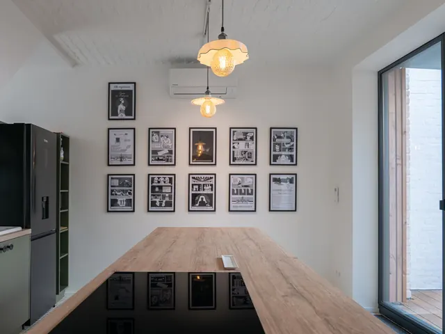 Cuisine et grande baie vitrée ouverte sur la terrasse, galerie de cadres en noir et blanc au mur, Camuche de Bettignies à Tournai