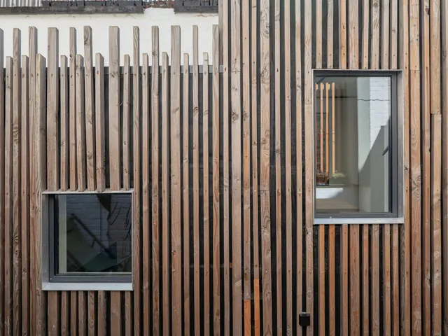 Façade en lattes de bois à deux fenêtres métalliques, vue depuis la terrasse, Camuche de Bettignies à Tournai