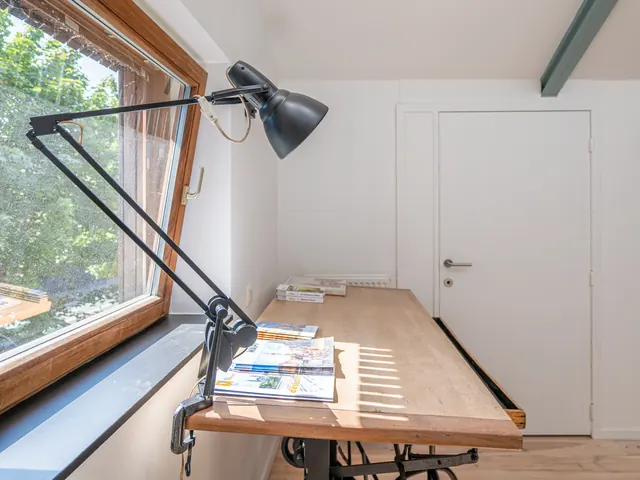Table à dessin d'architecte avec lampe articulée devant une fenêtre en bois, Camuche Beyaert à Tournai
