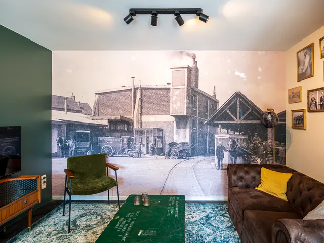 Séjour avec grande fresque ancienne de la Coopérative l'Avenir, canapé Chesterfield et fauteuil vert, Camuche Beyaert à Tournai