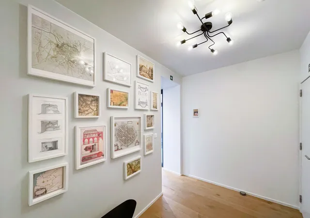 Couloir orné de cartes et de plans anciens encadrés, parquet en chêne, Camuche Boulenger à Tournai