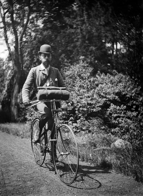 René Desclée à vélo sur un chemin de campagne, chapeau melon et sacoche enroulée sur le guidon, photographie ancienne, Camuche Desclée à Tournai