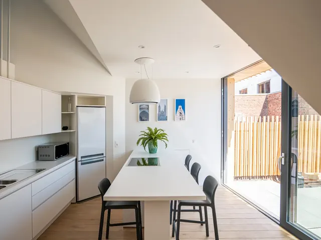 Cuisine avec îlot et grande baie coulissante sur la terrasse, Camuche Desclée à Tournai