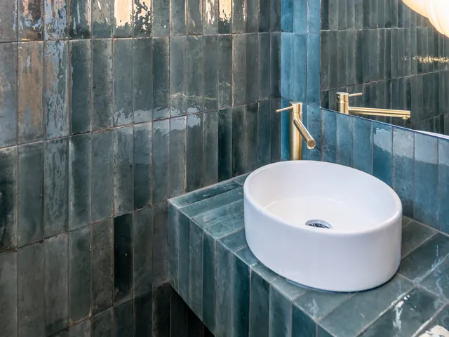 Salle de bain en carreaux émaillés bleu-vert avec vasque à poser et robinet en laiton, Camuche Lacoste à Tournai