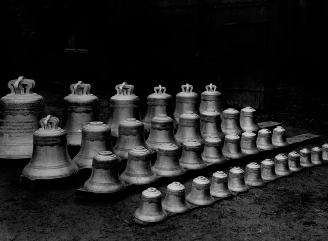 Jeu de cloches de carillon alignées par taille sur le sol de la cour, des plus grandes aux plus petites, photographie ancienne, Camuche Michiels à Tournai