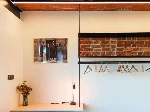 Chambre avec bureau en pin, penderie ouverte devant un mur de briques et photographie ancienne encadrée, Camuche Michiels à Tournai