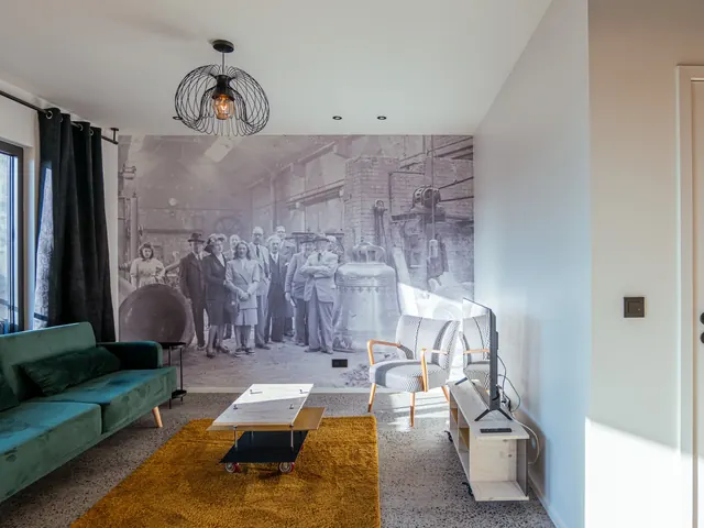 Séjour avec grande fresque photographique d'une ancienne fonderie de cloches, canapé en velours vert et tapis jaune, Camuche Michiels à Tournai