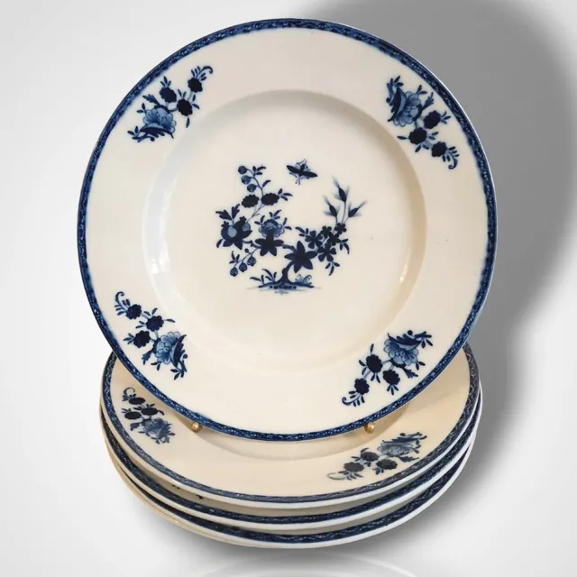 Pile d’assiettes en porcelaine blanche à décor bleu de fleurs et de papillon, bord à frise bleue, archive, Camuche Peterinck à Tournai