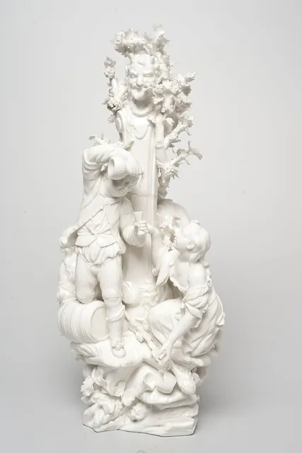 Groupe sculpté en porcelaine blanche : mascaron de satyre dans la vigne, jeune homme versant du vin d’une cruche et jeune femme aux raisins près d’un tonneau, archive, Camuche Peterinck à Tournai